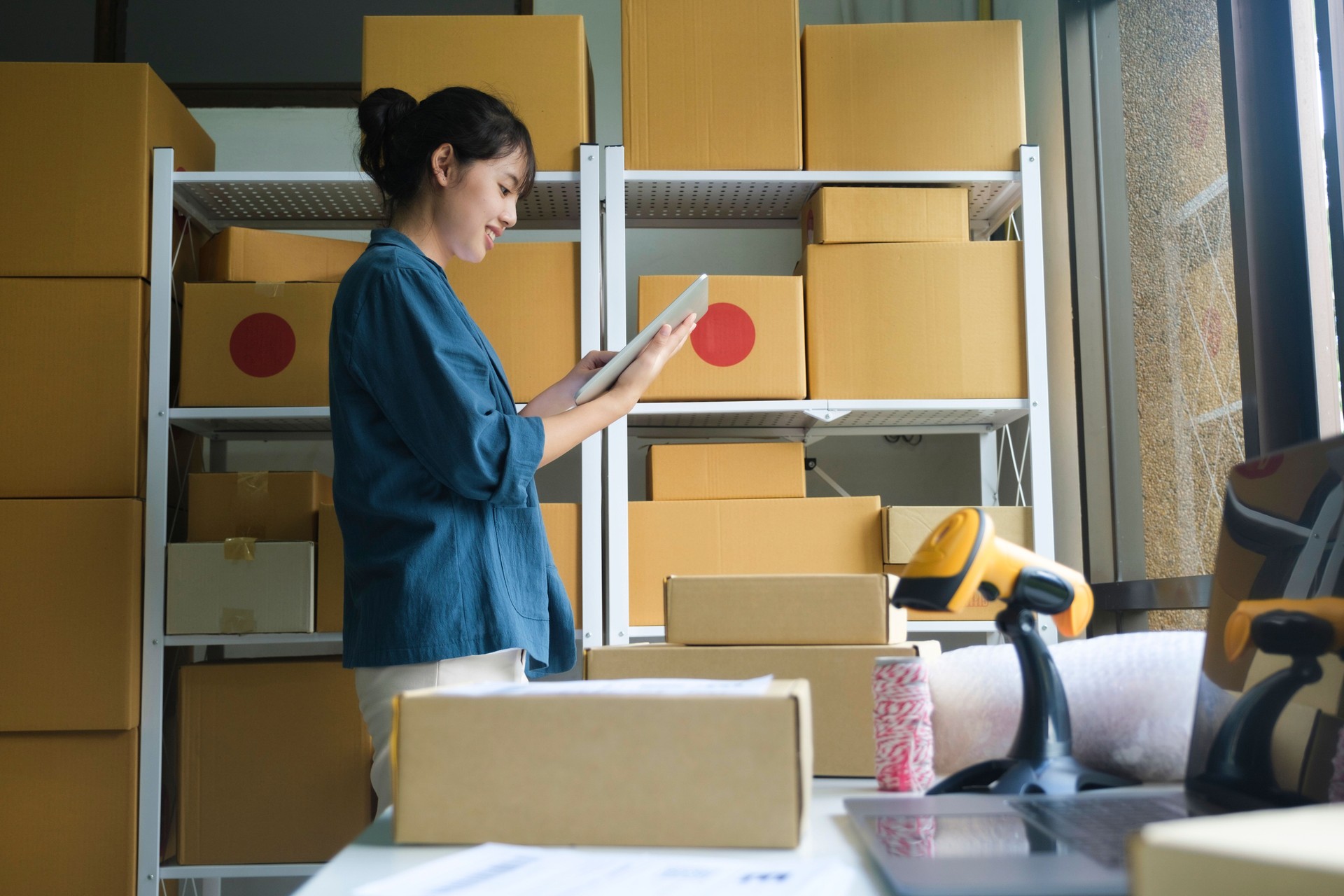 Online store owner checking orders for packaged product.